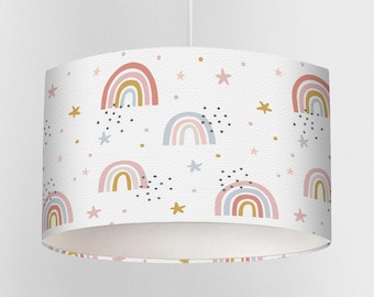 May include: A white lampshade featuring a repeating pattern of pastel rainbows, stars, and dots. The rainbows are in shades of pink, yellow, and blue. The stars and dots are in gold and black.