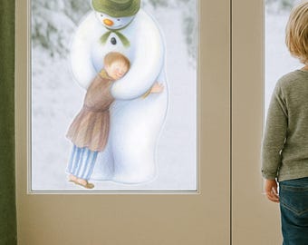 May include: A heartwarming illustration depicts a snowman embracing a child. The snowman wears a green hat and scarf, while the child is dressed in a brown outfit and blue striped pants. A young child stands nearby, looking at the scene.