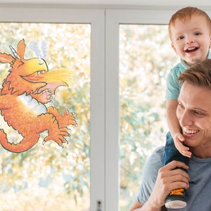 Peut inclure: Un père et son fils sourient. Le fils est assis sur les épaules de son père. Un dragon de dessin animé est sur la fenêtre derrière eux.