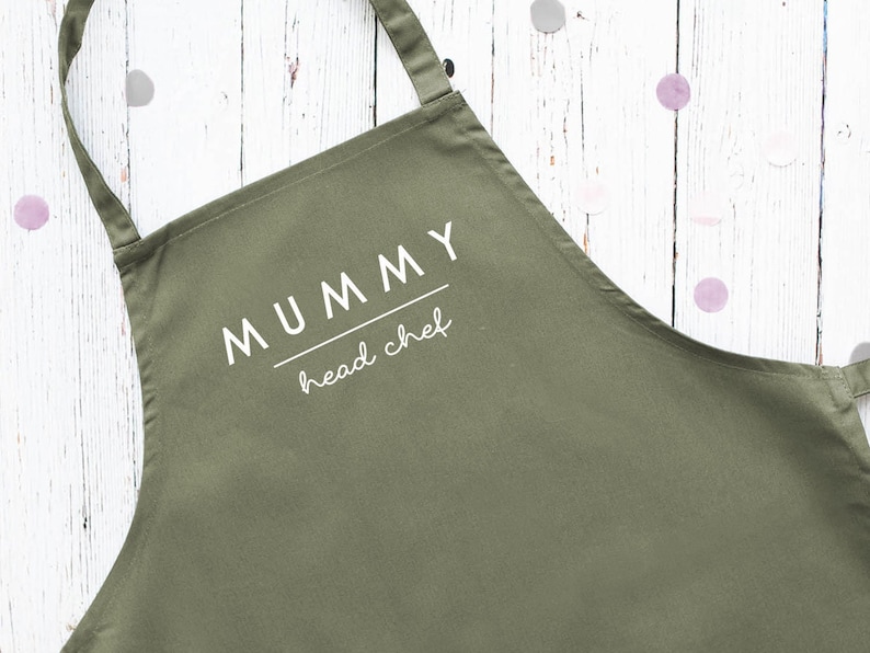 May include: A green apron with the text "MUMMY head chef" printed in white.