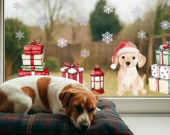 May include: A Jack Russell Terrier rests on a plaid pillow in front of a window decorated with snowflakes. A watercolor illustration of a puppy wearing a Santa hat sits near wrapped gifts and a lantern.