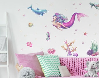 May include: A set of colorful mermaid wall decals featuring a mermaid with pink and purple hair, a dolphin, a seahorse, a starfish, coral, seaweed, and bubbles. The decals are perfect for adding a whimsical touch to a child's bedroom or playroom.
