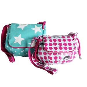 May include: Two small, colorful crossbody bags. One is turquoise with white stars, the other is white with pink polka dots and black panther silhouettes. Both have pink straps and accents.