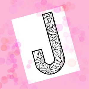 May include: A black and white illustration of the letter J with a floral design. The letter is outlined in black and filled with a pattern of daisies.