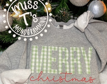 May include: A gray sweatshirt with the words "Merry Christmas" embroidered on the front. The word "Merry" is in green and white gingham and the word "Christmas" is in red cursive.