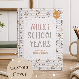 Może przedstawiać: Spersonalizowany szkolny album wspomnień zatytułowany "Millie's School Years" z kwiatowym i pasiastym wzorem. Okładka zawiera tekst "Memories to Treasure Forever" i naklejkę K-12. Kubek z ołówkami i mała roślina znajdują się w tle.