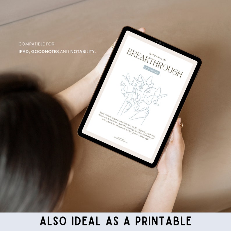 May include: A digital tablet displaying a break-up journal with a line drawing of butterflies and hands. The text on the screen reads "Break-Up Breakthrough Journal".
