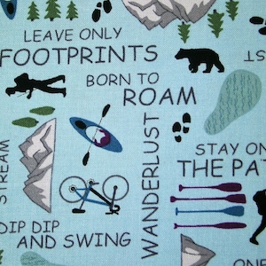 Könnte beinhalten: Hellblaues Gewebe mit Illustrationen und Text zum Thema Outdoor-Abenteuer. Enthält einen Bären, Berge, Fußabdrücke, Kajaks, Fahrräder und Sätze wie "Leave Only Footprints" und "Born to Roam". Geeignet für Basteln oder Heimdekoration.