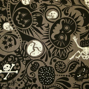 May include: Grey fabric featuring a repeating pattern of black and white Halloween-themed illustrations. The design includes skulls, skeletons, pumpkins, stars, moons, and other spooky elements. The overall theme is a festive, dark aesthetic.