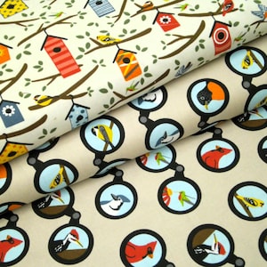 May include: Two fabrics with bird-themed patterns. One features birdhouses and birds on branches, the other has birds in magnifying glasses. The birdhouse fabric has a cream background with brown branches and colourful birdhouses. The magnifying glass fabric has a tan background.