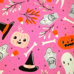 Può includere: Tessuto rosa con un motivo di Halloween con fantasmi, zucche, cappelli da strega, mais dolce, ossa e lapidi con la scritta "RIP" su di esse.