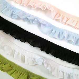 Könnte beinhalten: Fünf verschiedene Farben von Rüschenbesatz, darunter Schwarz, Weiß, Hellblau, Hellrosa und Grün.