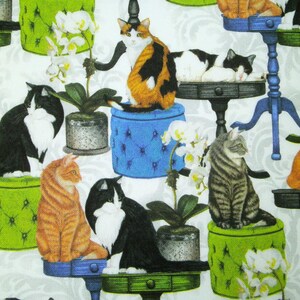 Könnte beinhalten: Ein Stoffmuster mit verschiedenen Katzen, die auf bunten, gepolsterten Hockern und kleinen Tischen sitzen, durchsetzt mit getopften weißen Orchideenpflanzen vor einem hellgrauen Hintergrund mit einem dezenten Damastmuster.