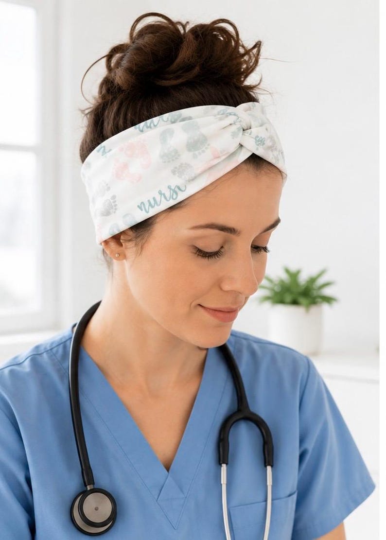 Pu&ograve; includere: Fascia bianca annodata, con un motivo di impronte di piedi di bambino rosa e grigio, e la parola "nurse". La persona indossa un camice blu e uno stetoscopio.