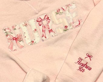 Love Shack Fancy Embroidered Nurse Sweatshirt.Pink bows, flowers, roses adorn this personalized sweatshirt. Custom fabric options available.