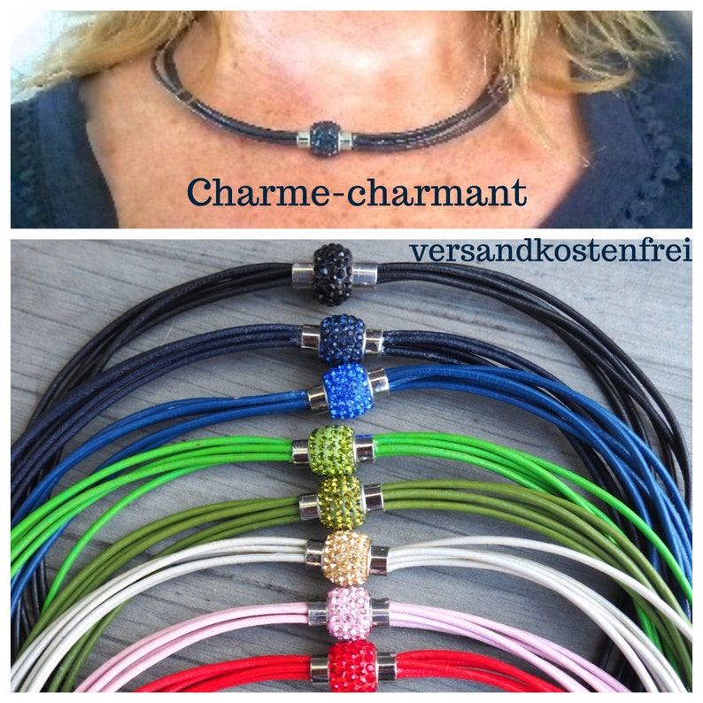Pu&ograve; includere: Un set di collane in pelle multicolori con chiusura magnetica. Le collane sono disponibili in nero, blu, verde, oliva, bianco, rosa e rosso. Ogni collana presenta un ciondolo di cristallo di un colore diverso. Il testo "Charme-charmant" e "versandkostenfrei" &egrave; visibile nell'immagine.