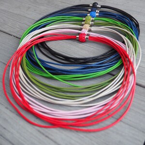 Pu&ograve; includere: Un set di collane in cordoncino di pelle di diversi colori con chiusure magnetiche. I cordoncini sono rossi, rosa, bianchi, verdi, blu, neri e altro ancora. Ogni cordoncino ha una perla di cristallo di colore diverso sulla chiusura.