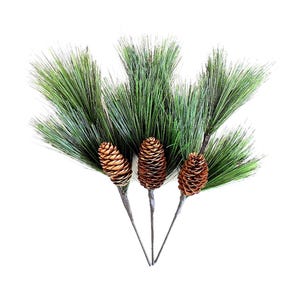 May include: Three artificial pine branches with long, thin, dark green needles and a single brown pinecone attached to each stem. The stems are thin and dark, converging at the bottom, creating a decorative botanical arrangement for display.