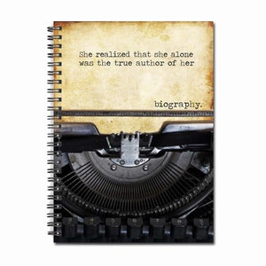 May include: A vintage typewriter with a quote about writing: "She realized that she alone was the true author of her biography."