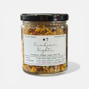 May include: A glass jar of "Arabian Nights" loose leaf tea, with a black lid. The label states "Turmeric Ginger Loose Leaf Tea" and "Caffeine Free." The jar contains a mix of dried herbs and spices, with a net weight of 50g.
