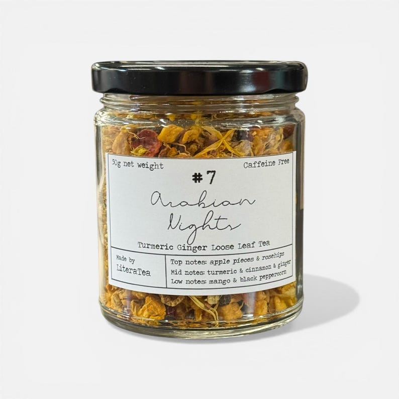 May include: A glass jar of "Arabian Nights" loose leaf tea, with a black lid. The label states "Turmeric Ginger Loose Leaf Tea" and "Caffeine Free." The jar contains a mix of dried herbs and spices, with a net weight of 50g.
