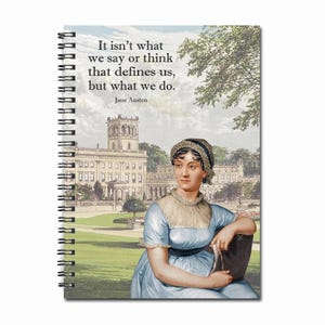 May include: A spiral bound notebook featuring a quote by Jane Austen: "It isn't what we say or think that defines us, but what we do." The cover depicts a vintage illustration of a woman in a blue dress and a white bonnet, seated in a garden with a large building behind her.