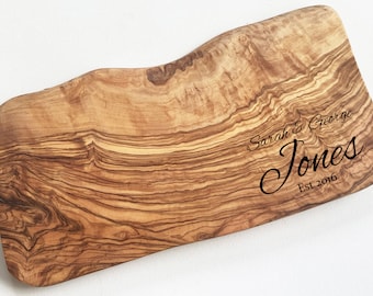 Puede incluir: Una tabla de cortar de madera de olivo personalizada con el texto "Sarah & George Jones Est 2016" grabado en la superficie.