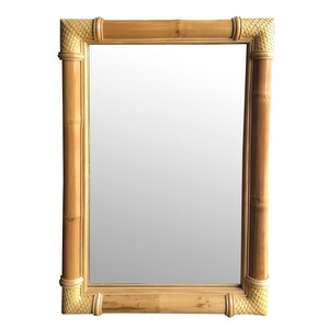 May include: A rectangular mirror with a natural bamboo frame. The frame has a woven design at the corners.