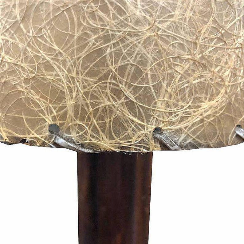 May include: A vintage table lamp with a brown wooden base and a beige lampshade with a woven texture.