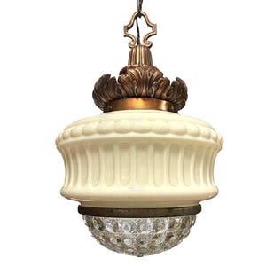 May include: Antique pendant light fixture with a cream-colored glass shade and a decorative bronze-colored metal top and accents. The bottom features a globe of faceted clear glass. The light hangs from a chain.
