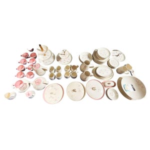 May include: A collection of white ceramic tableware with a delicate pink floral pattern. The set includes plates, cups, saucers, teacups, a teapot, and serving dishes. The plates have a diameter of approximately 10 inches.
