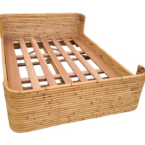 Puede incluir: Un marco de cama de bambú tejido natural con una cabecera y un piecero curvos. El marco tiene una base de listones para soporte.