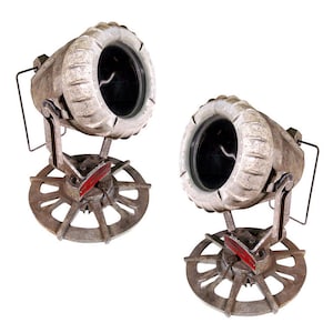 May include: Two vintage metal spotlights with a white and gray finish. Each spotlight has a round, black lens and a base with a circular, gear-like design.