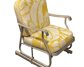 May include: A yellow and white patterned rocking chair with a metal frame. The chair has a comfortable cushion and is perfect for relaxing on a porch or patio.