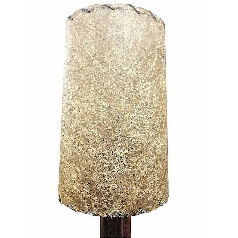 May include: A vintage lampshade with a beige, textured fabric. The fabric has a woven, string-like pattern.