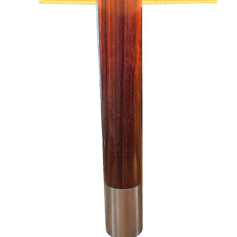 May include: A wooden lamp base with a dark brown wood grain and a silver metal base.