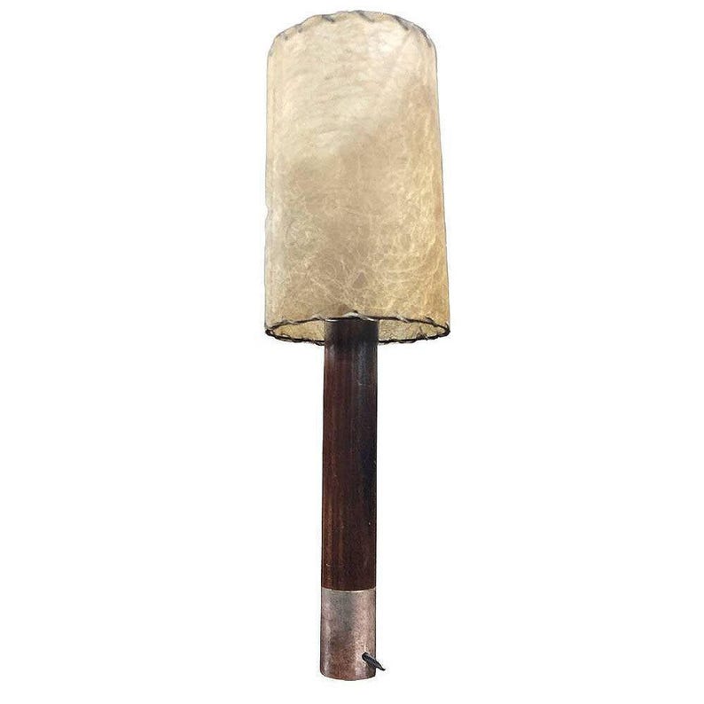 May include: A mid-century modern floor lamp with a brown wooden base and a beige, textured lampshade.
