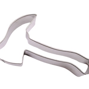 May include: A stainless steel axe-shaped cookie cutter. The cutter has a detailed outline of an axe head and handle. The metal has a shiny, reflective surface, and the design is suitable for baking.