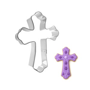 May include: A stainless steel cross-shaped cookie cutter next to a decorated purple cross-shaped cookie. The cookie has white and purple floral details and a light brown edge. The cutter is on a white background.