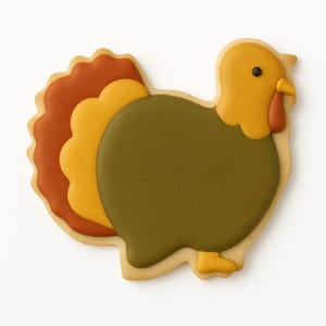 Puede incluir: Una galleta con forma de pavo con un borde marr&oacute;n claro. El pavo tiene un cuerpo verde, una cabeza amarilla y una car&uacute;ncula roja. Las plumas de la cola son naranjas, amarillas y marrones. Se utiliza un punto negro para el ojo.