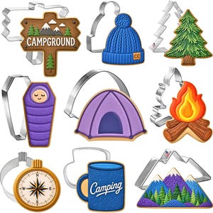 May include: A collection of nine metal cookie cutters paired with matching decorated cookies featuring camping themes including a campground sign, a blue knit hat, a pine tree, a sleeping bag, a purple tent, a campfire, a compass, a mug, and mountains.