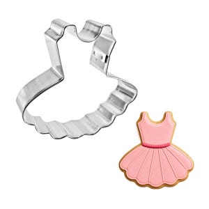 May include: A stainless steel dress-shaped cookie cutter next to a decorated cookie. The cookie is pink with a brown outline and a pink belt. The cutter has a scalloped bottom edge.