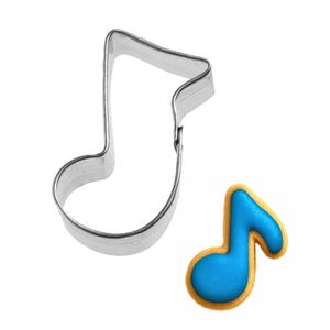 May include: A stainless steel cookie cutter in the shape of a musical eighth note sits next to a decorated cookie. The cookie is blue with a yellow border, also in the shape of an eighth note. The items are on a white background.