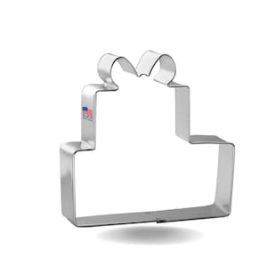May include: A silver metal cookie cutter shaped like a gift box with a bow on top. Made in the USA.