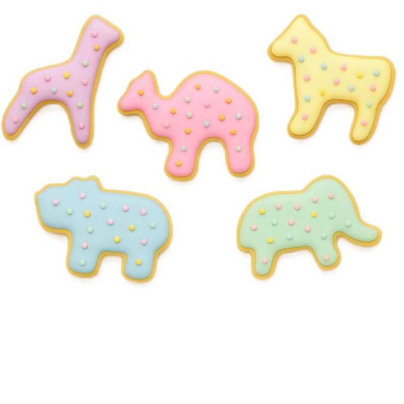 May include: Five animal-shaped cookies: a giraffe, camel, horse, hippo, and elephant. Each cookie has a pastel color and is decorated with small, colorful dots. The cookies have a yellow outline.