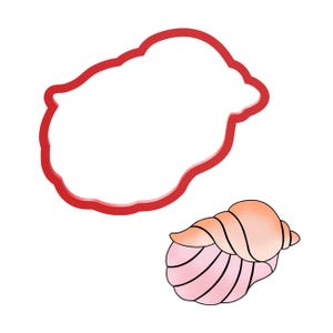 Puede incluir: Un contorno rojo con forma de nube y un cortador de galletas con forma de concha. La concha es rosa y melocotón con líneas negras. El cortador de galletas es para hornear y manualidades.