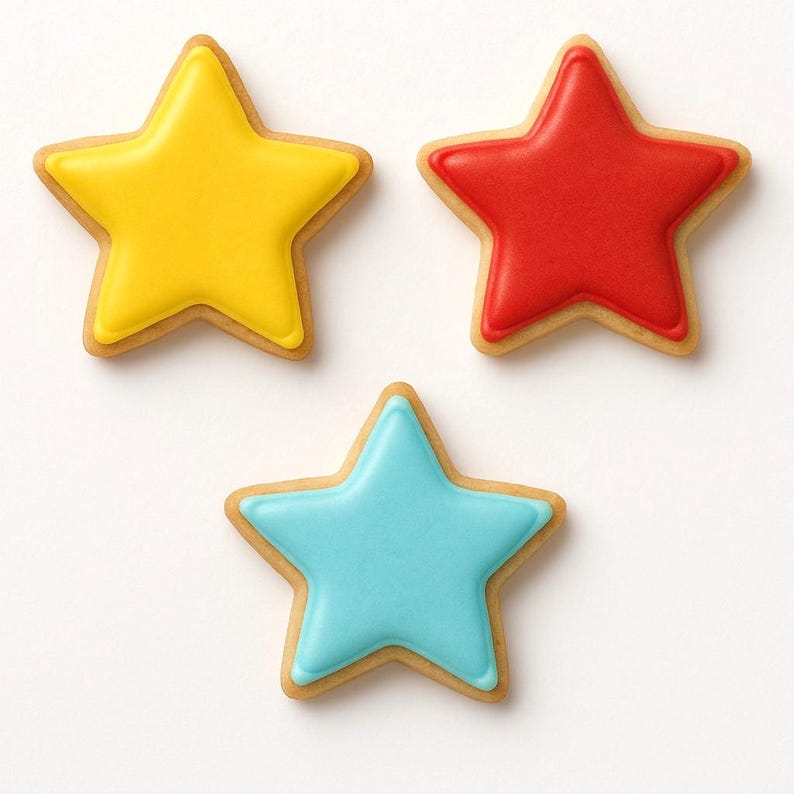 May include: Three star-shaped cookies with smooth icing. One cookie is bright yellow, one is vibrant red, and one is light blue. Each cookie has a light brown baked edge visible around the perimeter of the colored icing, creating a distinct border.