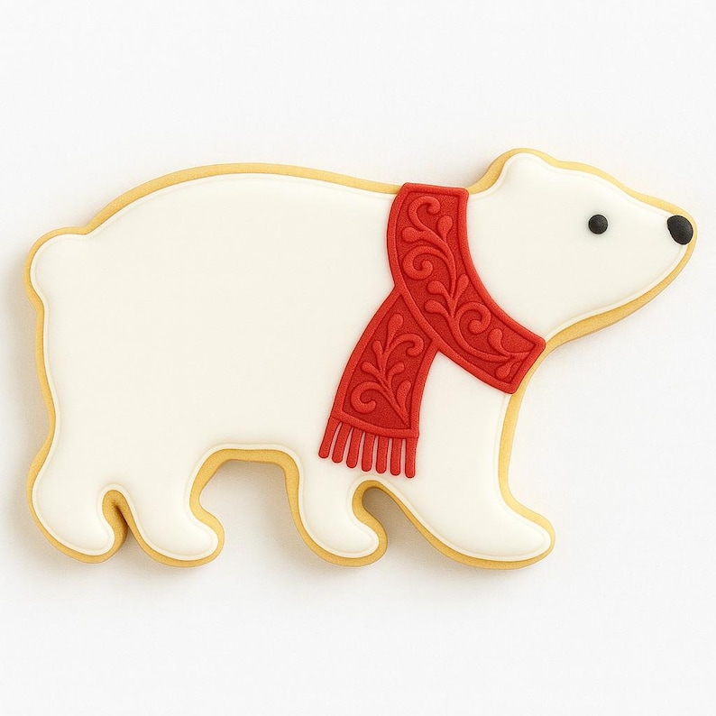 May include: A polar bear cookie with white icing and a red scarf with a decorative pattern. The cookie has a yellow outline and black eyes. The bear is in a walking pose.