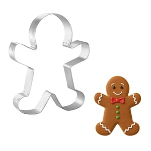 May include: A gingerbread man cookie next to a silver-colored metal gingerbread man cookie cutter. The cookie is brown with white icing details, a red bow tie, and green buttons. The cutter is in the shape of a gingerbread man.