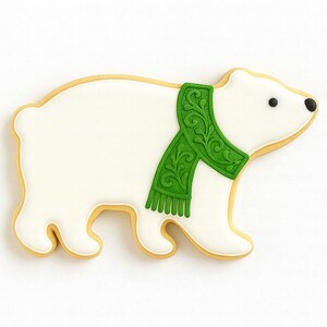 May include: A polar bear cookie with white icing and a green scarf. The cookie has a light brown outline and black eyes. The scarf has a detailed design.